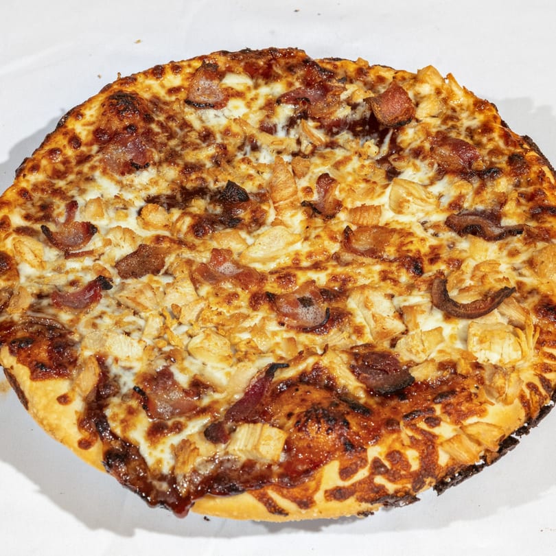 Bear's Den Pizzeria's BBQ chicken and bacon pizza, with melted cheese and a crispy crust.